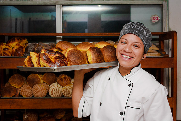 woman holding tray of fresh baked bread