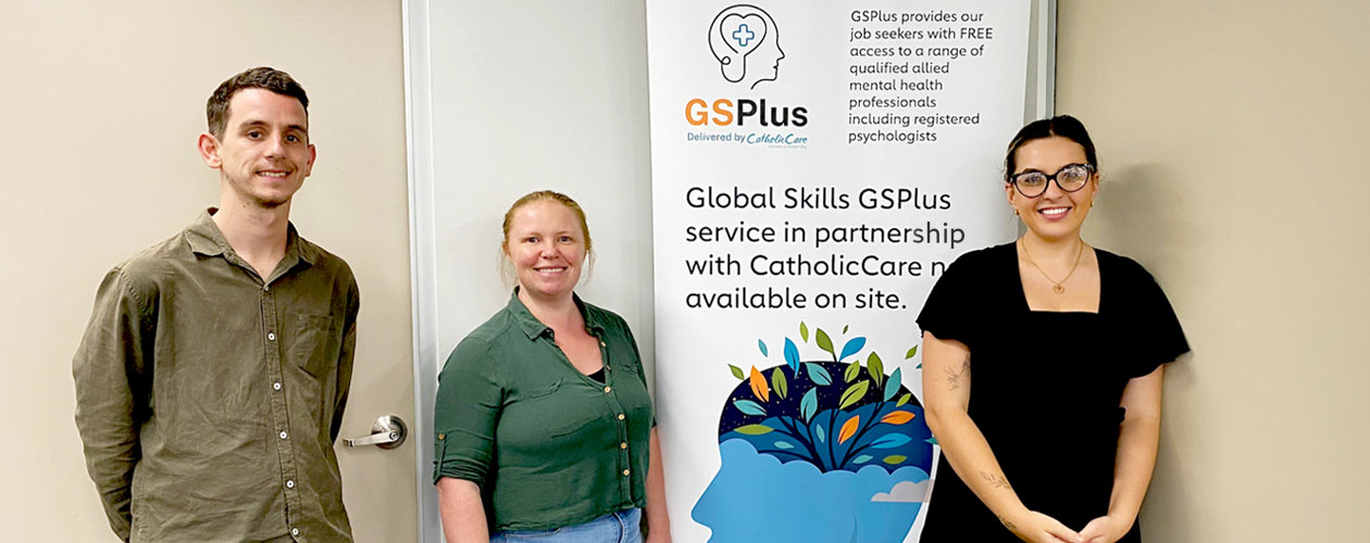 CatholicCare counsellors and a Global Skills staff member standing in front of our GSPlus banner