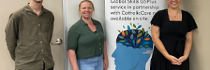 CatholicCare counsellors and a Global Skills staff member standing in front of our GSPlus banner