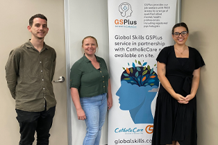 CatholicCare counsellors and a Global Skills staff member standing in front of our GSPlus banner