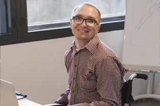 Man in wheelchair working at a laptop