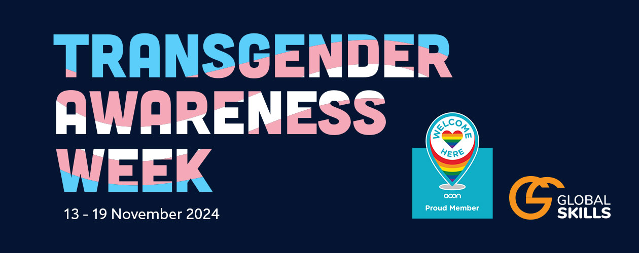 Text reading Transgender Awareness Week, featuring the trans flag within the letters, on a navy blue background. Image includes our Welcome Here membership logo.