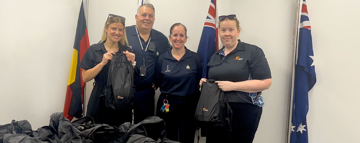 Justice Services Manager Laura handing backpacks over to Corrections team