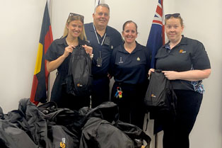 Justice Services Manager Laura handing backpacks over to Corrections team