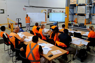 RF Scanning Skillset students learning at desks in a warehouse setting