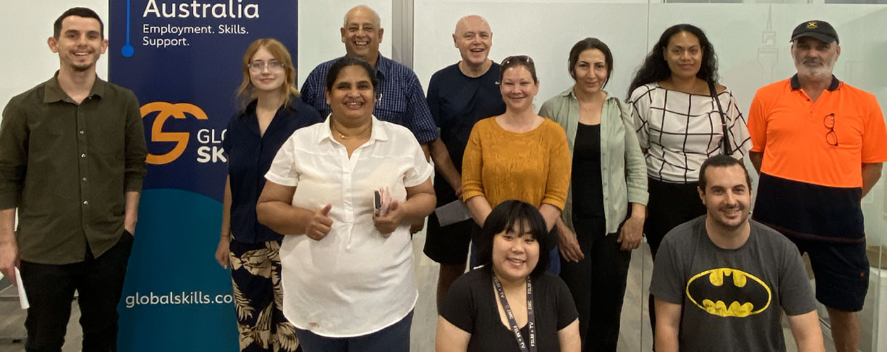 Training Graduates standing next to a banner including Workforce Australia and Global Skills logos