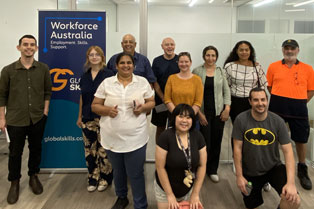 Training Graduates standing next to a banner including Workforce Australia and Global Skills logos