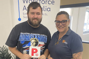 Bradley proudly holding his P plate, alongside Melissa, his Employment Consultant