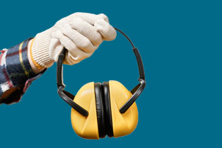 Hand holding black and yellow safety ear muffs